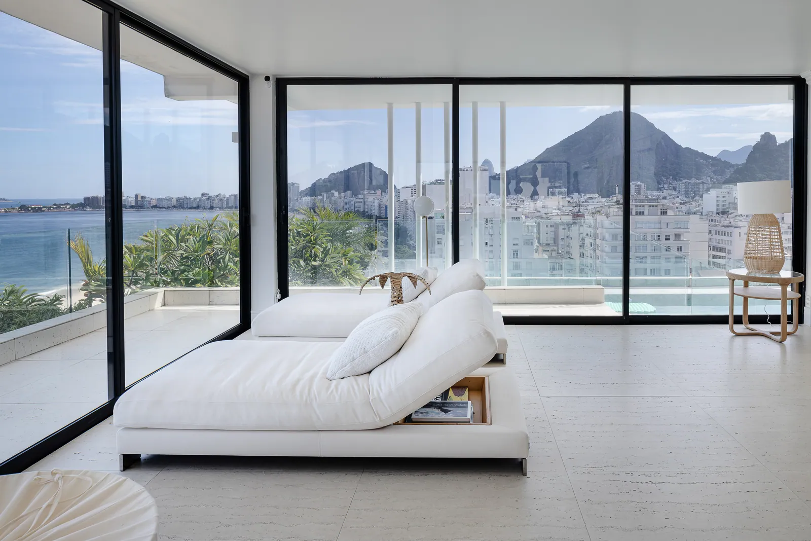 Daybed against the glass, the hills of Rio beyond