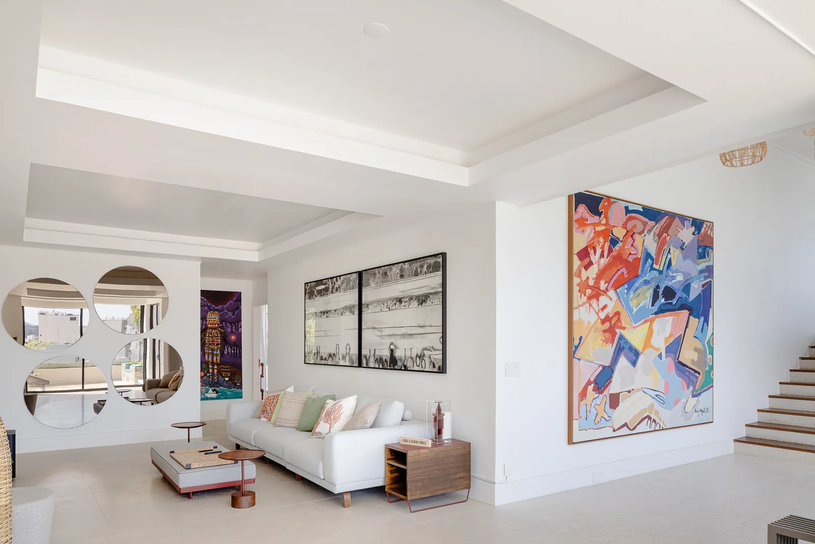 Living room with round mirrors and a contemporary canvas