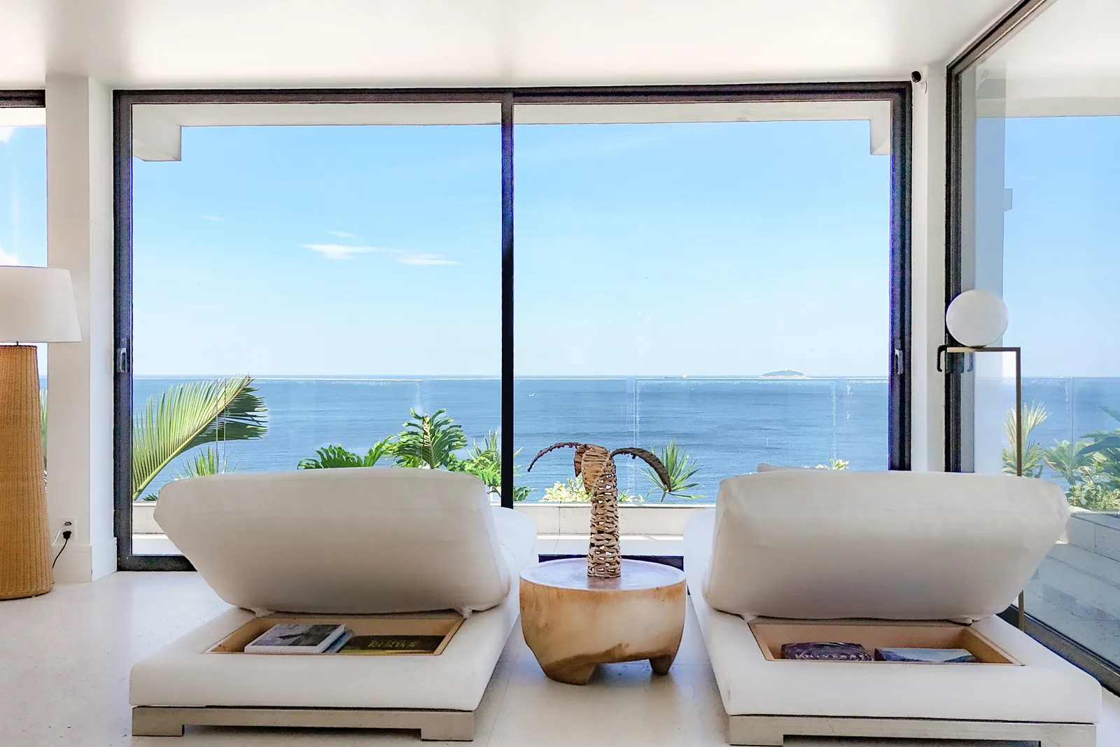 Two armchairs facing the glass and the open sea