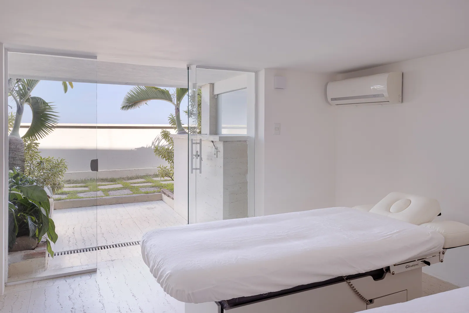 Treatment table beside the glass, terrace and sea beyond