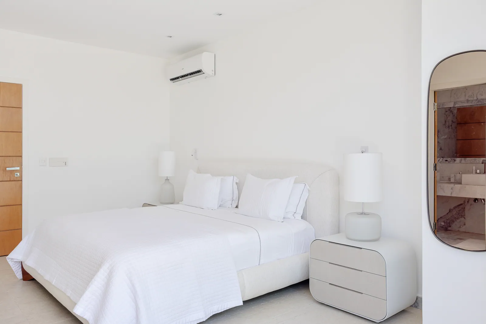 Bedroom in white with rounded bedside tables