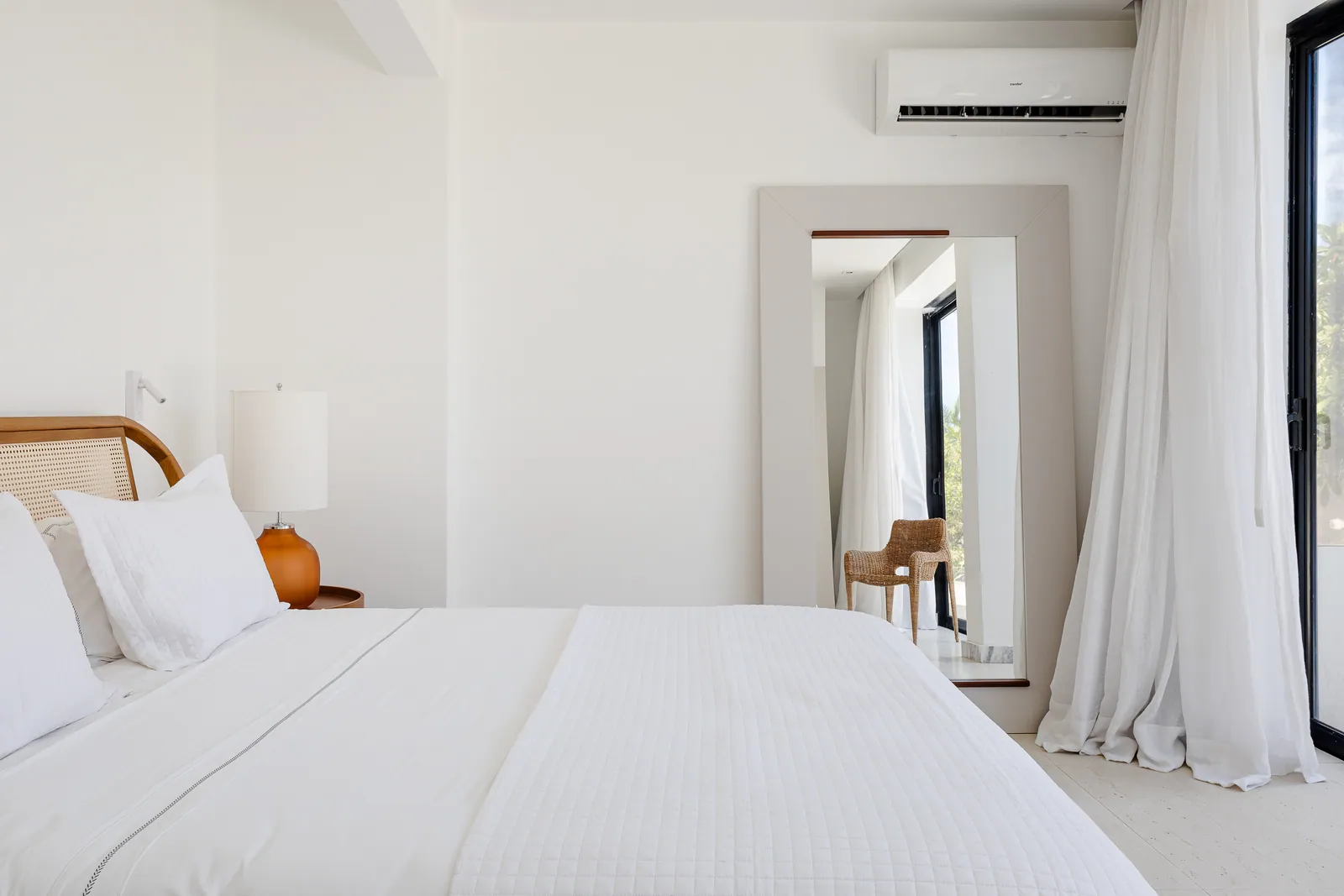 Bedroom with full-height mirror and sheer curtains
