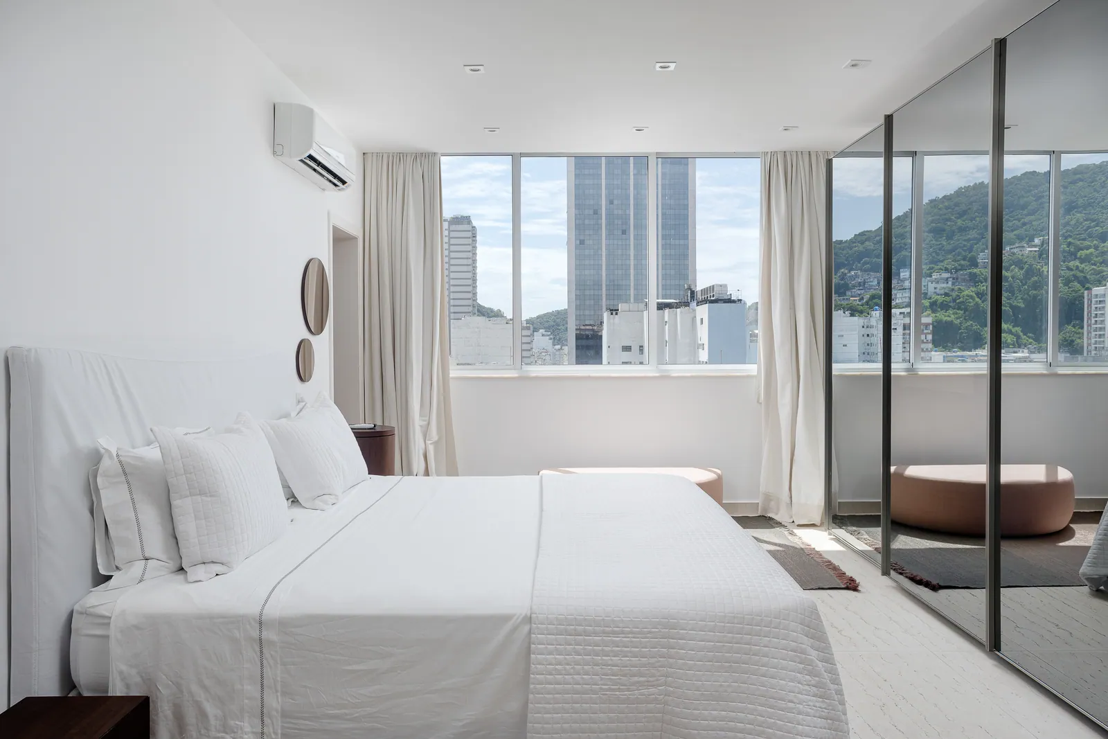 Bedroom with mirrored wall and city view