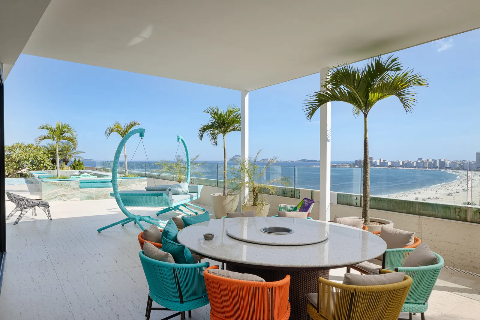 Outdoor dining for twenty, hanging chairs and the beach behind