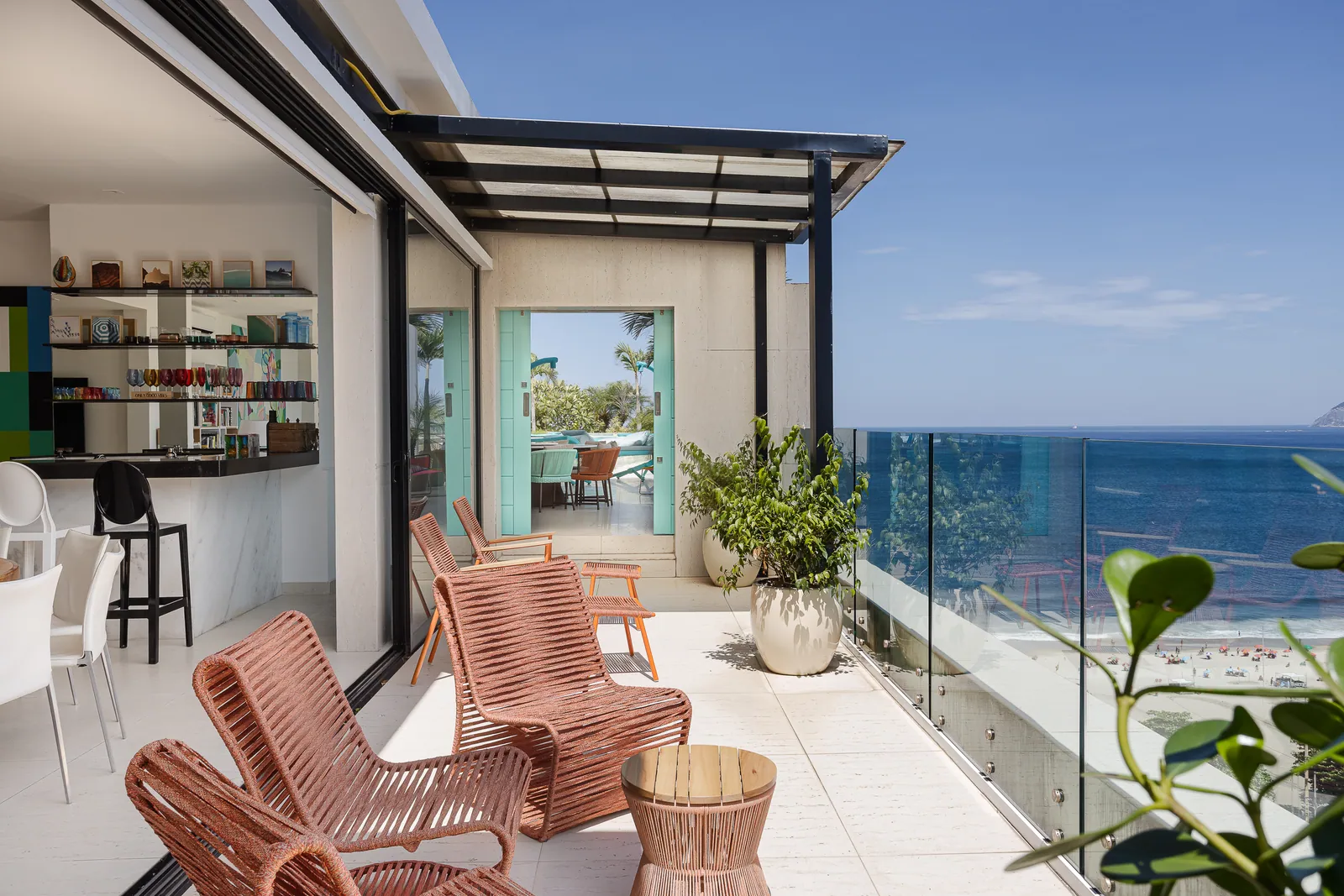 Covered terrace with bar shelving and seating, ocean beyond